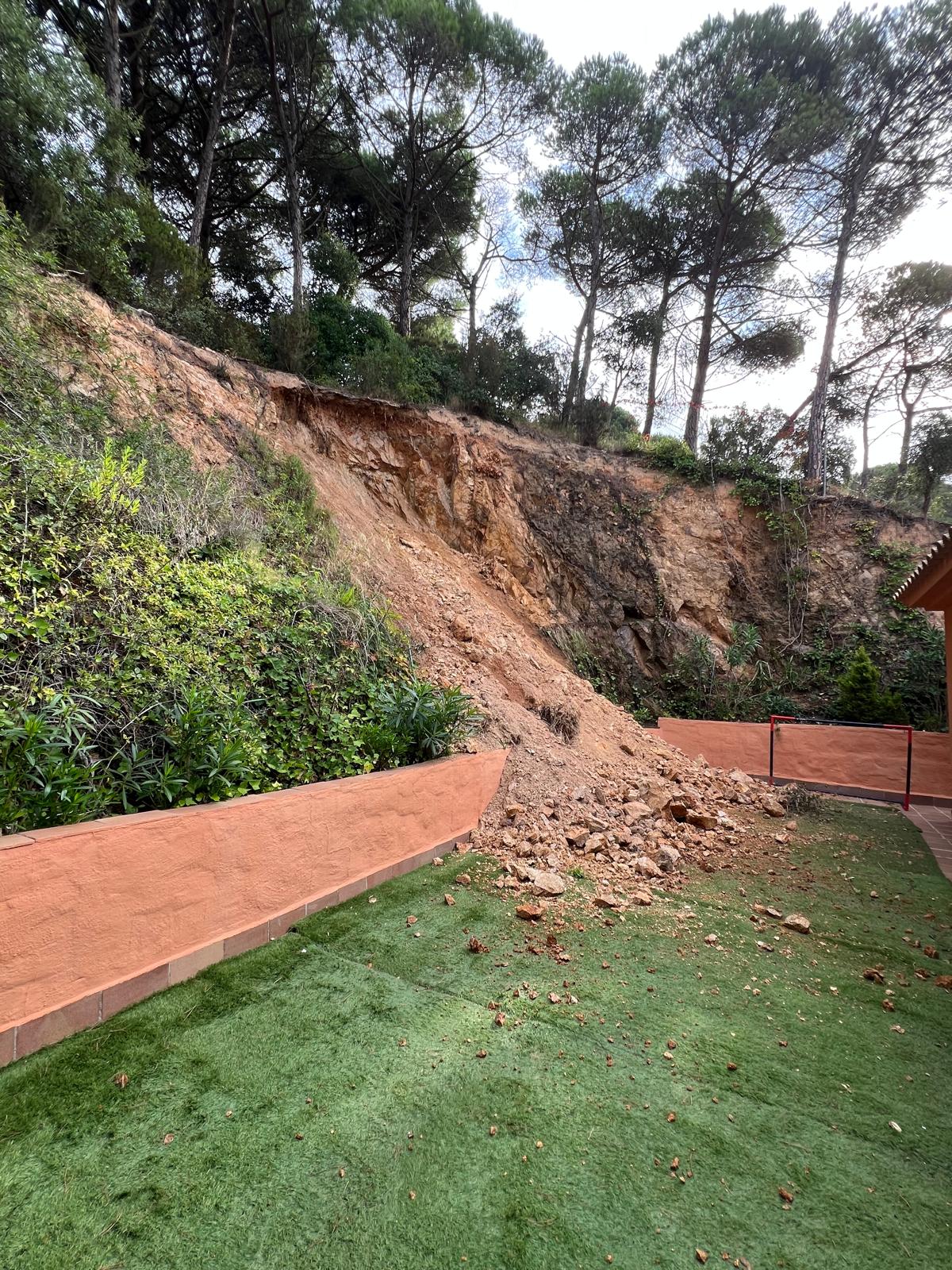 Rock and soil accumulation in garden due to slope failure
