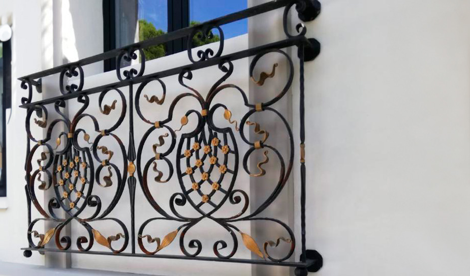 Balcón de hierro forjado con medallones y detalles ornamentales