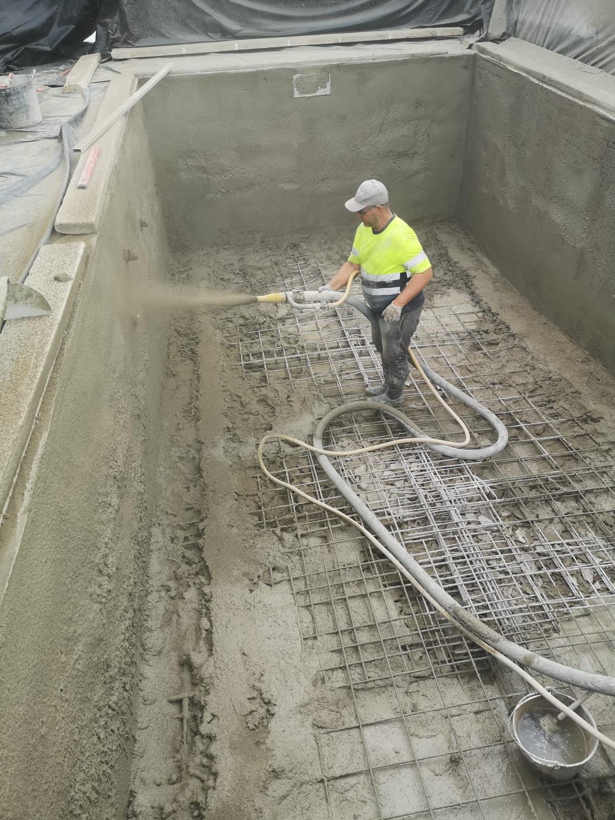 Técnico proyectando hormigón (gunitado) sobre la armadura del vaso