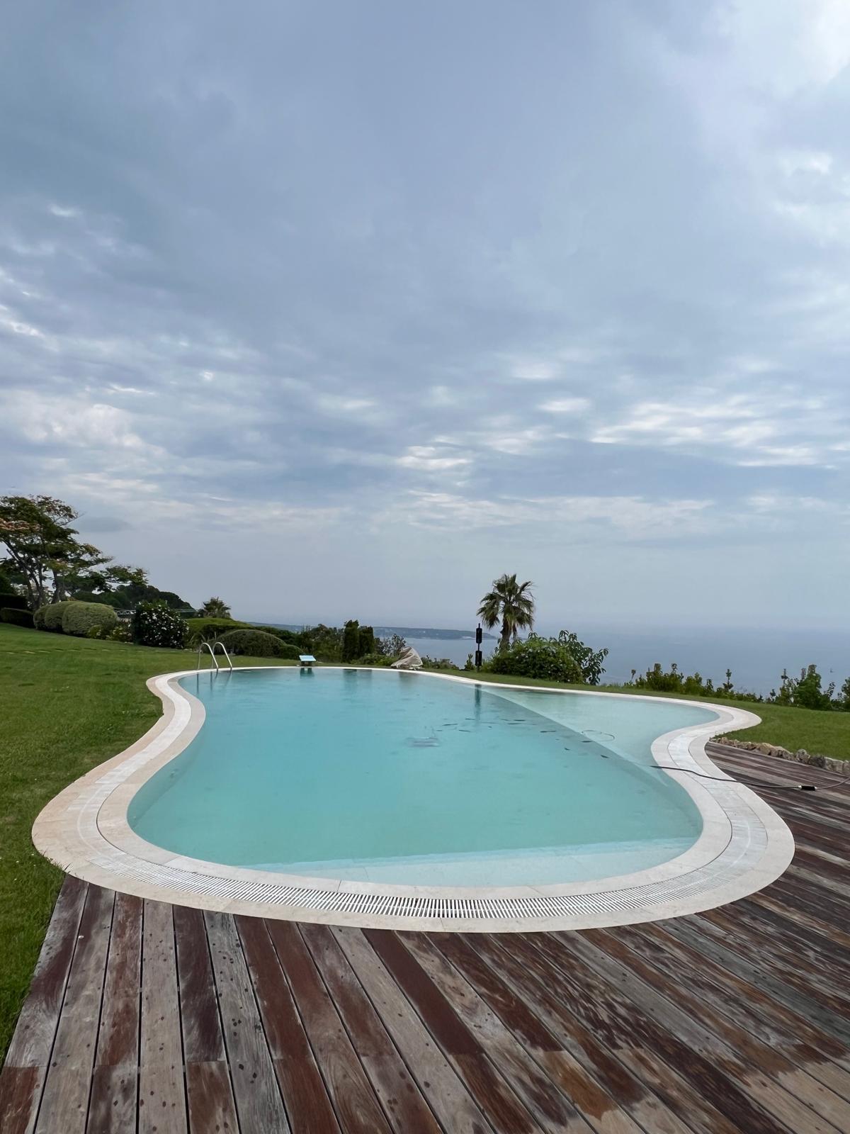 Piscina terminada con borde curvo y vistas al mar (borde infinito)