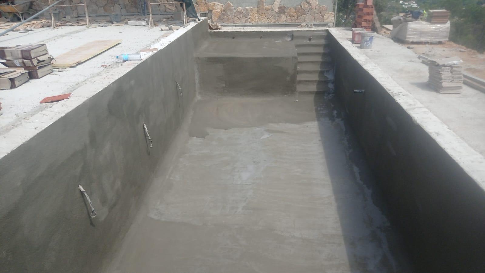 Excavación del terreno para piscina junto a vivienda; vaciado y perfilado del vaso