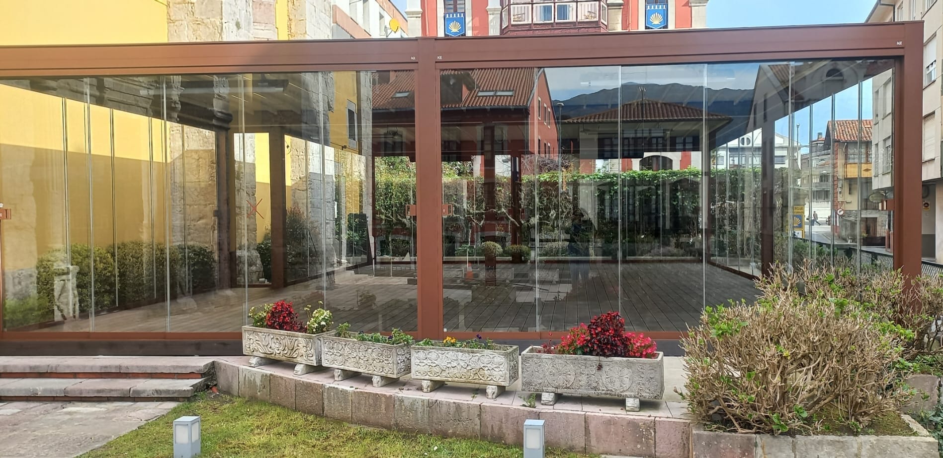 Cerramiento perimetral con paneles de vidrio en estructura de aluminio para proteger la zona exterior del viento y la lluvia