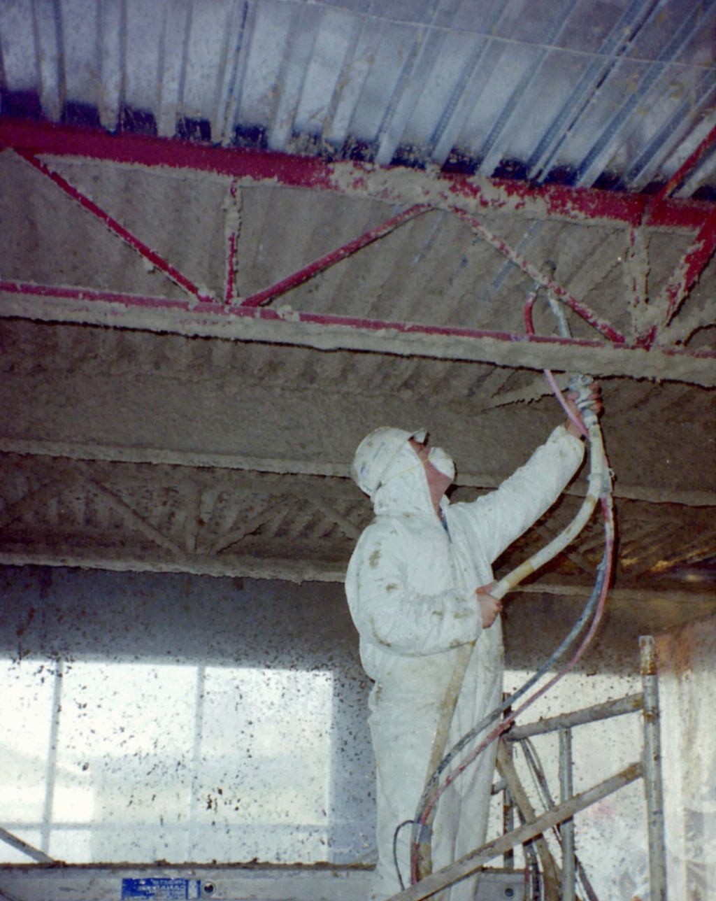 aplicación de mortero ignífugo proyectado sobre vigas de acero en un interior