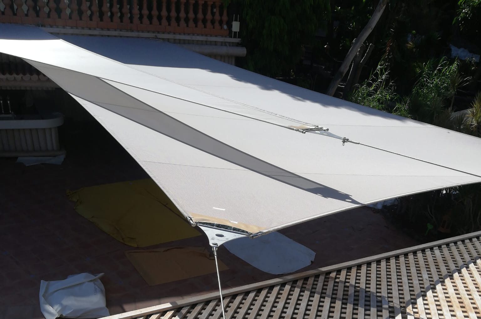 Proceso de instalación de arquitectura textil: equipo trabajando en altura con arnés y medidas de seguridad durante el tensado y fijación