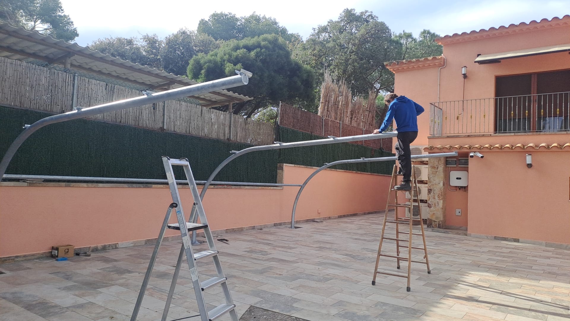 Montaje de la estructura metálica de una cubierta para coche en vivienda